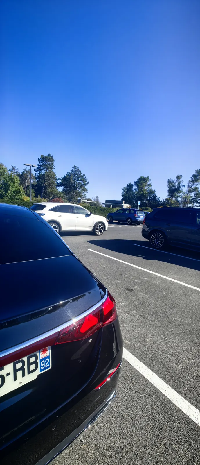 Chauffeur-driven Mercedes E-Class waiting in the Normandy American Cemetery car park at Colleville-sur-Mer