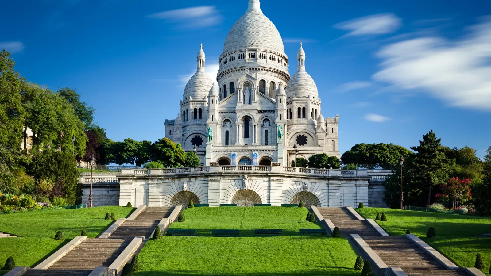 Sacré-Cœur basilica on the hill of Montmartre above its stairs and lawns, Paris