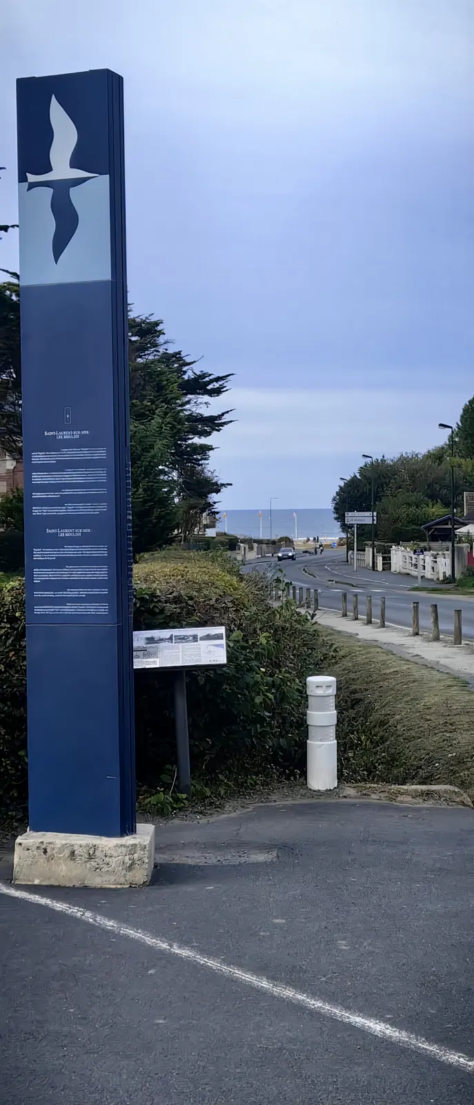 Saint-Laurent-sur-Mer – Les Moulins totem with the road running down to Omaha Beach, the D-3 draw of the D-Day landings